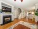 Open-concept living room with hardwood floors, a fireplace, and a view of the dining area at 151 E Morehouse Ave, Mooresville, NC 28117