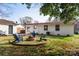 An inviting backyard with a fire pit circled by Adirondack chairs on a spacious lawn at 1621 Keeling Pl, Charlotte, NC 28210