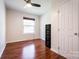 Neutral bedroom with dark wood floors, ceiling fan, and a large window at 1621 Keeling Pl, Charlotte, NC 28210