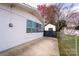 Home exterior featuring a white brick wall, multiple windows, and a fenced in yard with storage shed at 1621 Keeling Pl, Charlotte, NC 28210