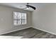 Well lit bedroom features modern ceiling fan, neutral walls, and gray vinyl flooring at 2013 Barkley Cir, Monroe, NC 28112