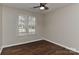 This light-filled bedroom includes hardwood floors, a ceiling fan, and a window with a pleasant outdoor view at 2013 Barkley Cir, Monroe, NC 28112