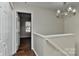 Well-lit hallway with wood floors, white trim, and a stylish light fixture at 2013 Barkley Cir, Monroe, NC 28112