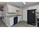 Cozy kitchen featuring white cabinets, stainless steel sink, and a modern, black refrigerator at 2013 Barkley Cir, Monroe, NC 28112