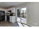 Well-lit kitchen features white cabinets, stainless steel appliances, and glass sliding door to deck at 2013 Barkley Cir, Monroe, NC 28112