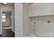 Laundry room featuring storage and a washer hookup next to the entrance of another room with hardwood flooring at 2013 Barkley Cir, Monroe, NC 28112