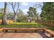 View of the backyard from a wooden deck, showcasing a well-maintained lawn and a charming shed at 2309 Shenandoah Ave, Charlotte, NC 28205