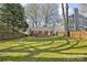 Expansive backyard featuring a deck, lush green lawn, mature trees, and a privacy fence at 2309 Shenandoah Ave, Charlotte, NC 28205