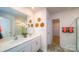 Bright bathroom featuring a double sink vanity with white countertops, decorative wall art and access to the walk in closet at 3021 Sassafras Trl, Gastonia, NC 28056