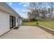 Backyard with gray siding, black patio doors, patio with stone retaining wall and privacy fence at 3919 Chatterleigh Dr, Monroe, NC 28110