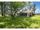Spacious backyard with lush green grass, mature trees, and an enclosed porch at 404 E 1St St, Cherryville, NC 28021