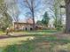 Expansive backyard with mature trees, deck, and outdoor seating area at 4216 Maureen Dr, Charlotte, NC 28205