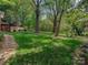 Expansive backyard with lush lawn, mature trees, and a charming stone walkway to the backyard at 4216 Maureen Dr, Charlotte, NC 28205