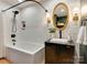 Well lit bathroom with white subway tile, dark vanity, oval mirror and combo shower and tub at 4216 Maureen Dr, Charlotte, NC 28205