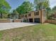 Lovely brick home with an attached two-car garage and landscaped front yard and a sunny sky at 4216 Maureen Dr, Charlotte, NC 28205