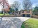 Expansive driveway leads to a brick home with a two-car garage and well-maintained landscaping at 4216 Maureen Dr, Charlotte, NC 28205