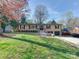 Charming brick home with a well-manicured lawn, mature trees, and a driveway leading to a two-car garage at 4216 Maureen Dr, Charlotte, NC 28205