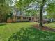 Beautiful brick home with a well-maintained lawn, lush landscaping, and mature shade trees at 4216 Maureen Dr, Charlotte, NC 28205