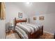 Cozy bedroom with sloped ceilings, a wood-frame bed, and a decorative bedside table at 4436 Roberta Rd, Concord, NC 28027