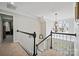 Well-lit hallway with carpeted stairs, white railing, and chandelier that adds charm at 4436 Roberta Rd, Concord, NC 28027