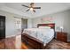 Elegant main bedroom featuring a barn door, ceiling fan, and wood floors, offering comfort and style at 4436 Roberta Rd, Concord, NC 28027