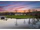 Stunning aerial view of waterfront home with lush lawn and lake access at twilight at 49461 River Run Rd, Albemarle, NC 28001