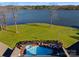 Aerial view of lakeside property with pool, patio, and meticulously landscaped yard at 49461 River Run Rd, Albemarle, NC 28001