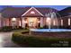 Elegant brick home featuring a circular driveway with a fountain and manicured landscaping at 49461 River Run Rd, Albemarle, NC 28001