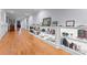 Long hallway lined with wall to wall display shelving with light and hardwood floors at 49461 River Run Rd, Albemarle, NC 28001