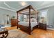 A luxurious main bedroom featuring a four-poster bed, hardwood floors, and stylish décor at 49461 River Run Rd, Albemarle, NC 28001