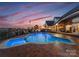 Stunning pool area at dusk, illuminated with lights and featuring comfortable outdoor seating overlooking the lake at 49461 River Run Rd, Albemarle, NC 28001