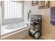 Bright bathroom featuring a luxurious soaking tub under a window, paired with a towel rack and a storage shelf at 514 Saint Johns Dr, Salisbury, NC 28144