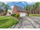 Side view of a brick home features an attached two-car garage and well-maintained landscaping at 514 Saint Johns Dr, Salisbury, NC 28144