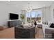 Bright living room with hardwood floors, modern decor, and a sliding glass door leading to a balcony at 5719 Castlerea Dr, Charlotte, NC 28217