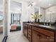 Bathroom features a double sink vanity with gray countertops, wood cabinets, and a glass shower with natural light at 5731 Castlerea Dr, Charlotte, NC 28217