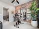 Bonus room with workout space features exposed brick wall, mirror, stationary bike, and stylish decor at 5731 Castlerea Dr, Charlotte, NC 28217