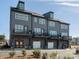 Rear view of upscale townhomes featuring private balconies, garages, and modern architectural design at 5731 Castlerea Dr, Charlotte, NC 28217