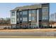 View of modern townhomes with gray, white, and brown siding, well-manicured landscaping, and welcoming front entrances at 5731 Castlerea Dr, Charlotte, NC 28217