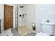 Modern bathroom highlighting a glass-enclosed shower, pebble flooring, and a rustic barn door accent at 5943 Charing Pl, Charlotte, NC 28211