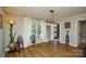 Well-lit living room with hardwood floors, stylish lighting, and ample natural light through a large window at 5943 Charing Pl, Charlotte, NC 28211