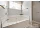 Bathroom featuring a corner tub and a shower with neutral wall colors at 7124 Bevington Woods Ln, Charlotte, NC 28277