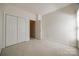 Bedroom featuring neutral walls, carpet floor, closet, and interior door at 7124 Bevington Woods Ln, Charlotte, NC 28277