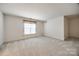 Bonus room with carpet, neutral walls, and a window with floral curtains at 7124 Bevington Woods Ln, Charlotte, NC 28277