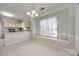 Dining area view to the kitchen with a large bright window and pendant lighting at 7124 Bevington Woods Ln, Charlotte, NC 28277