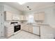 Well-lit kitchen with cabinets, tile floors, and white appliances at 7124 Bevington Woods Ln, Charlotte, NC 28277