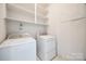 Laundry room featuring a white washer and dryer, plus storage shelves at 7124 Bevington Woods Ln, Charlotte, NC 28277