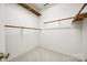 Walk-in closet with carpet, white walls, and wooden shelving with bars at 7124 Bevington Woods Ln, Charlotte, NC 28277