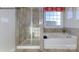 This bright bathroom features a glass-enclosed shower, soaking tub, and large window at 7645 Bainbridge Rd, Sherrills Ford, NC 28673