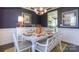 Stylish dining room with a white dining set, dark blue walls, and an adjacent open kitchen at 7645 Bainbridge Rd, Sherrills Ford, NC 28673