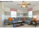 Living room featuring a gray sofa, striped accent wall, two windows, and modern ceiling fan at 7645 Bainbridge Rd, Sherrills Ford, NC 28673